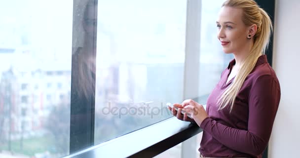 Жіночий менеджер, використовуючи мобільний телефон в інтер'єрі офісу — стокове відео