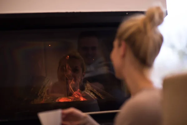 Jeune femme buvant du café devant la cheminée — Photo