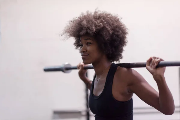 Mujer negra levantando barra vacía — Foto de Stock