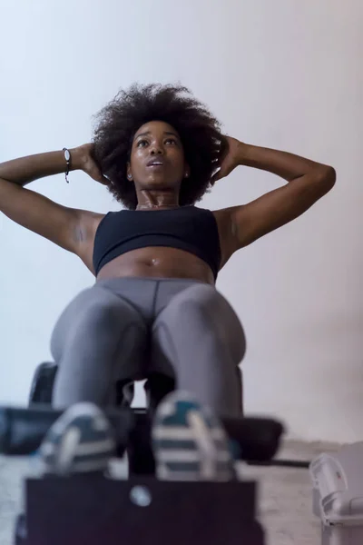 Μαύρη γυναίκα κάνει sit ups στο γυμναστήριο — Φωτογραφία Αρχείου