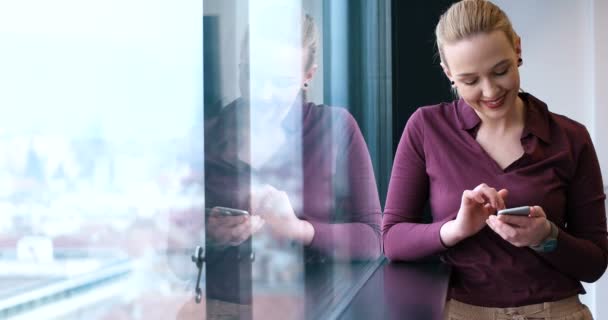 Femme gestionnaire à l'aide de téléphone cellulaire à l'intérieur du bureau — Video