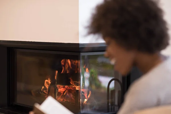 Чернокожая женщина дома читает книгу — стоковое фото