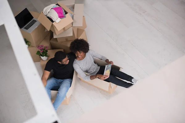 Casal afro-americano brincando com material de embalagem — Fotografia de Stock