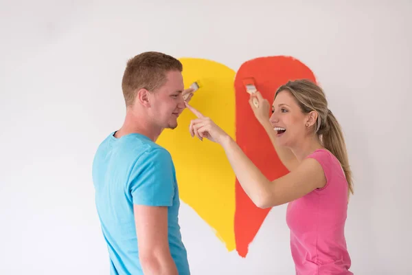 Paar malt ein Herz an die Wand — Stockfoto