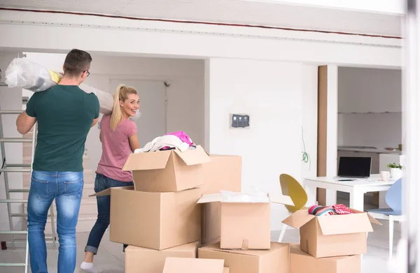 Casal carregando um tapete se mudando para casa nova — Fotografia de Stock