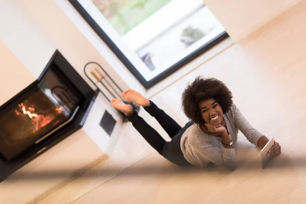 在地板上使用平板电脑的黑女人 — 图库照片