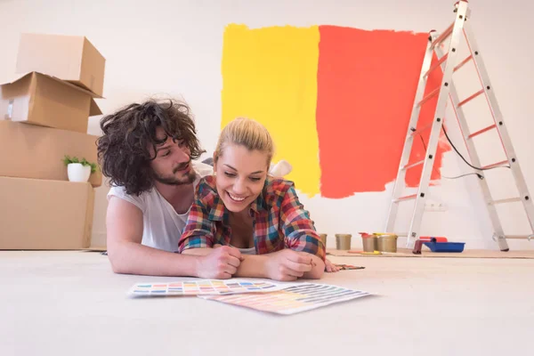 Feliz jovem casal relaxante após a pintura — Fotografia de Stock