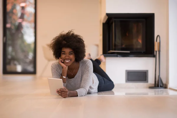 Чорна жінка використовує планшетний комп'ютер на підлозі — стокове фото