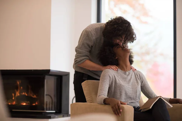 Pareja multiétnica abrazándose frente a la chimenea —  Fotos de Stock