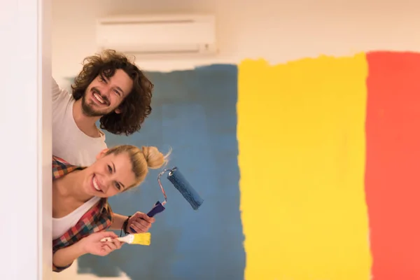 Retrato de una pareja pintando la pared interior — Foto de Stock