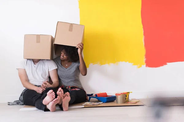 Молода багатоетнічна пара грає з картонними коробками — стокове фото