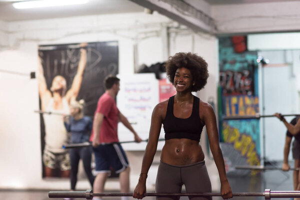 black woman lifting empty bar