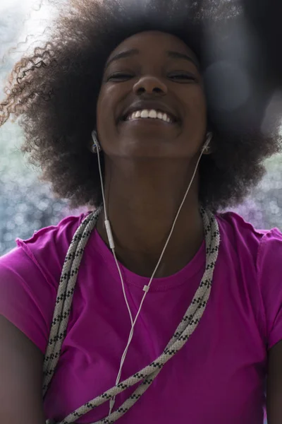 Portrét mladé afro americké ženy v tělocvičně při poslechu mus — Stock fotografie