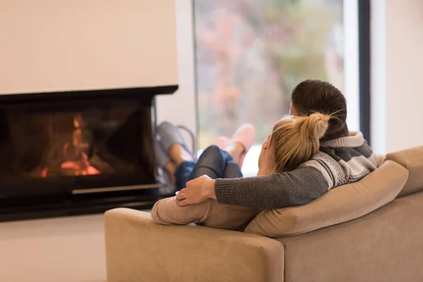 Pareja joven frente a la chimenea —  Fotos de Stock