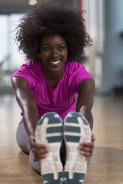 Mujer en un gimnasio estiramiento y calentamiento —  Fotos de Stock