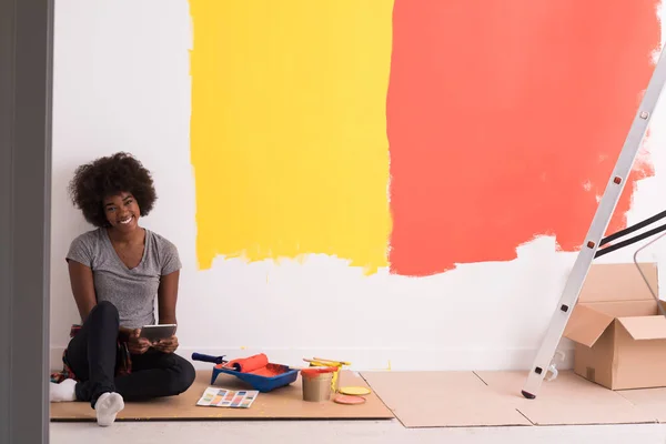 Negro pintor femenino sentado en el suelo — Foto de Stock