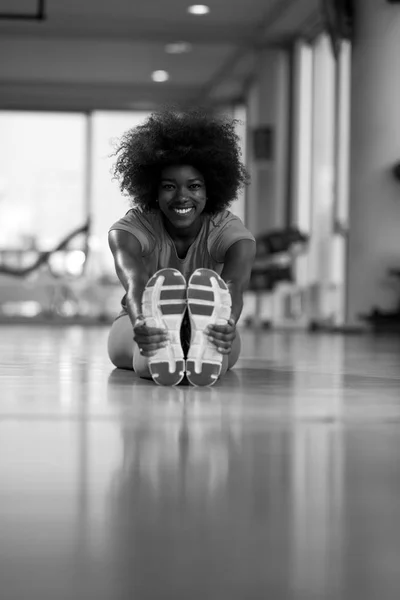 Mujer en un gimnasio estiramiento y calentamiento — Foto de Stock