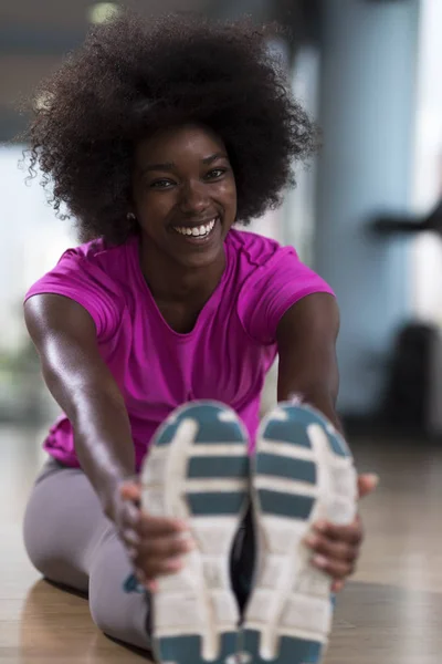 Frau im Fitnessstudio dehnt sich und wärmt sich auf — Stockfoto