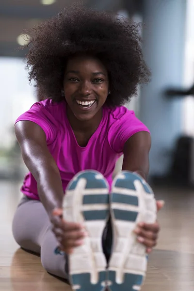 Woman in a gym stretching and warming up — Stock Photo, Image