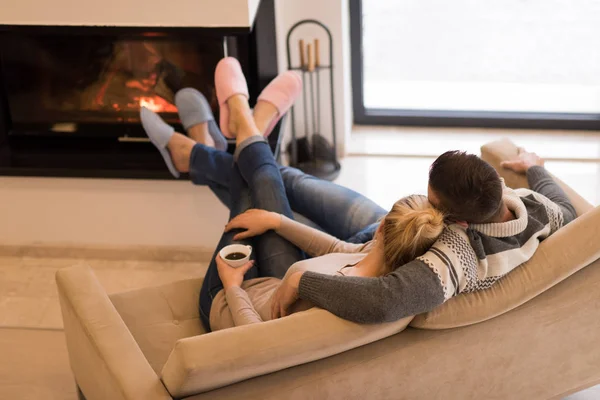 Pareja joven frente a la chimenea —  Fotos de Stock