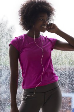 portrait of young afro american woman in gym while listening mus clipart