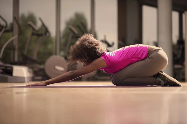 Afroamerikanska kvinnan utöva yoga i gymmet — Stockfoto