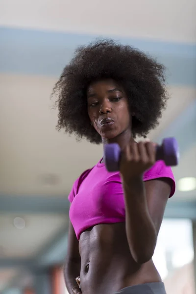Mujer haciendo ejercicio en un gimnasio crossfit con mancuernas —  Fotos de Stock