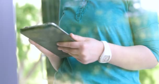 Vrouw met behulp van Tablet PC thuis bij het raam — Stockvideo