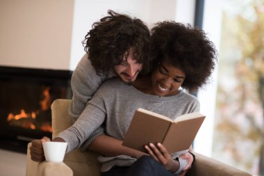 çok ırklı çift şöminenin önünde sarılma