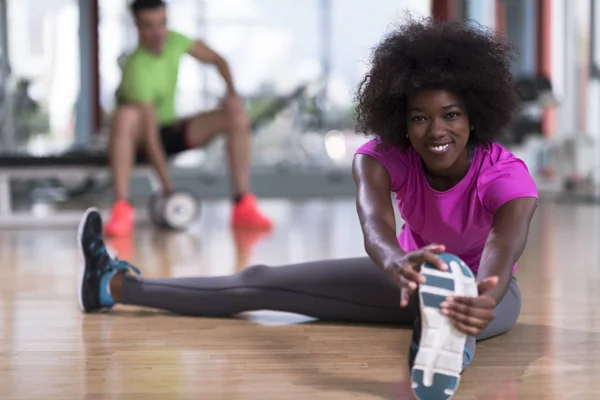 Kvinna i ett gym stretching och värmer upp — Stockfoto