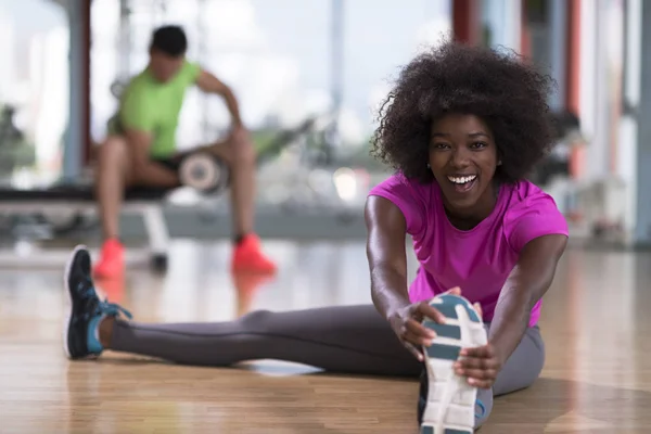 Frau im Fitnessstudio dehnt sich und wärmt sich auf — Stockfoto