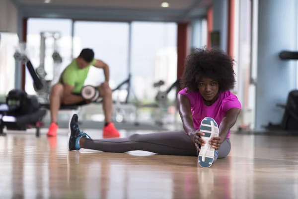 Kvinna i ett gym stretching och värmer upp — Stockfoto