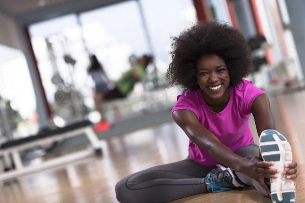 Frau im Fitnessstudio dehnt sich und wärmt sich auf — Stockfoto