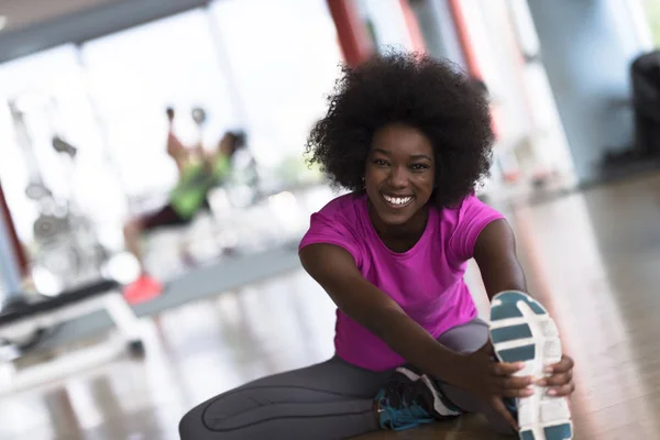 Frau im Fitnessstudio dehnt sich und wärmt sich auf — Stockfoto