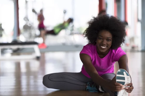 Frau im Fitnessstudio dehnt sich und wärmt sich auf — Stockfoto