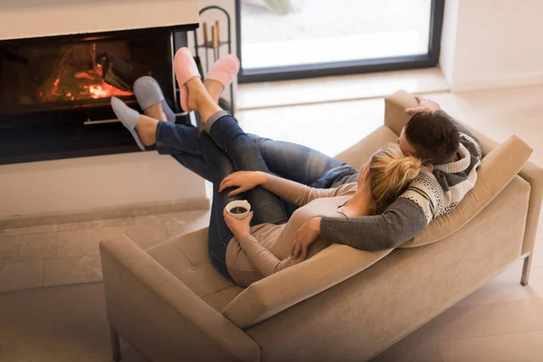 Pareja joven frente a la chimenea —  Fotos de Stock