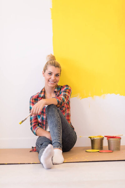 young female painter sitting on floor
