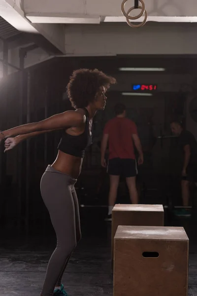 Černý atletka provádí box skoky v tělocvičně — Stock fotografie