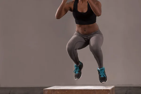 Černošky žena provádí box jumps v tělocvičně — Stock fotografie