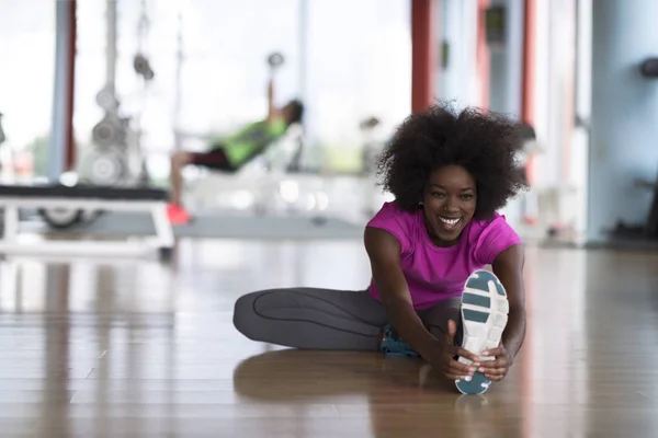 Frau im Fitnessstudio dehnt sich und wärmt sich auf — Stockfoto