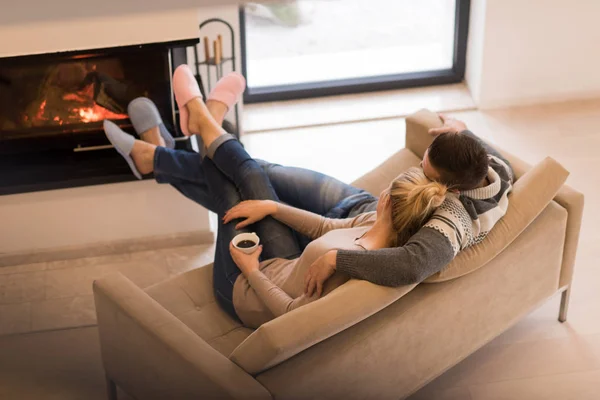 Jeune couple devant la cheminée — Photo