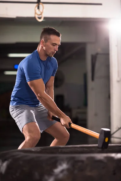 Entrenamiento del hombre con el martillo y el neumático tractor —  Fotos de Stock