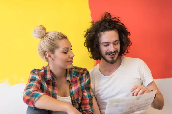 Feliz jovem casal relaxante após a pintura — Fotografia de Stock