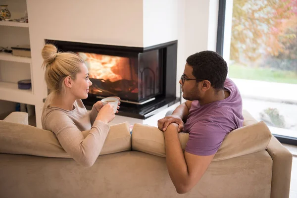 Pareja joven multiétnica frente a la chimenea —  Fotos de Stock