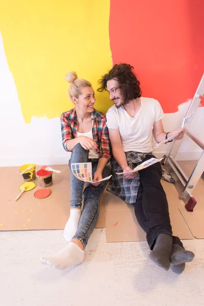 Счастливая молодая пара расслабляется после рисования — стоковое фото