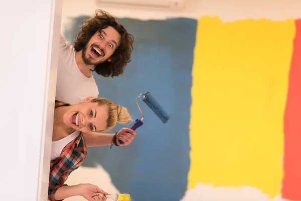 Retrato de una pareja pintando la pared interior — Foto de Stock