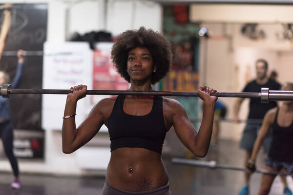black woman lifting empty bar