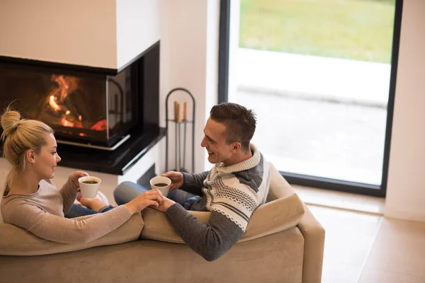 Pareja joven frente a la chimenea —  Fotos de Stock