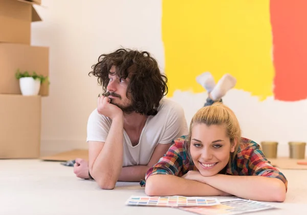 Feliz jovem casal relaxante após a pintura — Fotografia de Stock