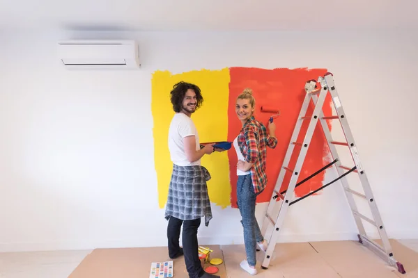 couple painting interior wall